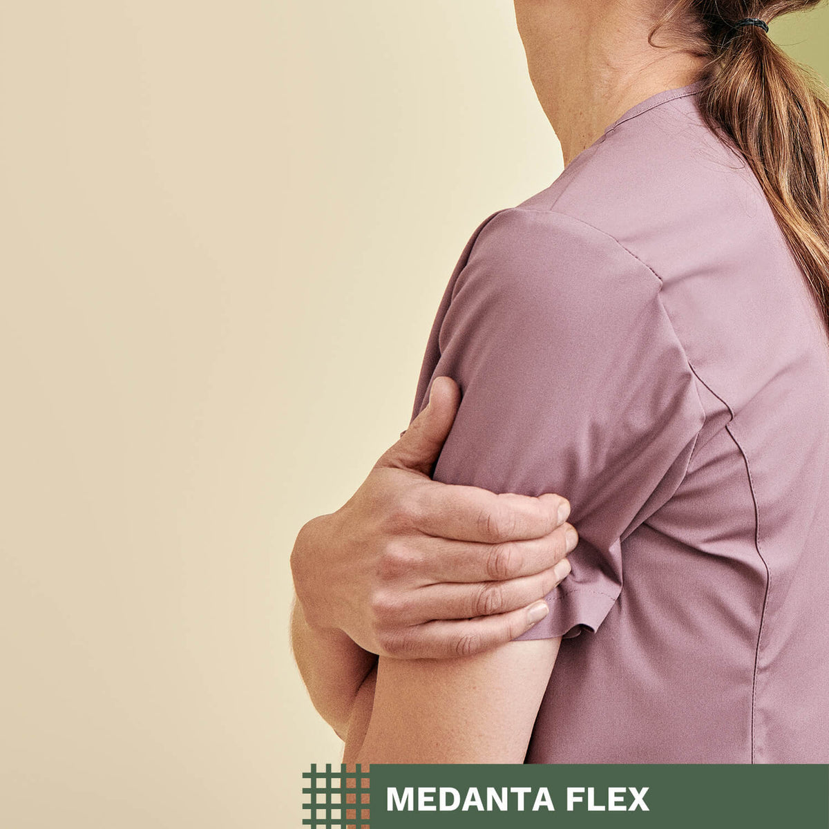Roosanvärinen työpaita hoitajan yllä, beigellä taustalla, Medanta Flex -tekstigrafiikka