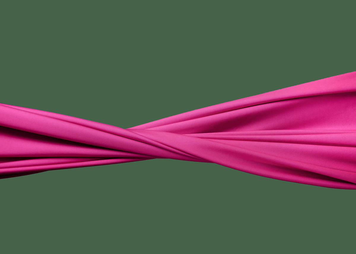 Pinkki, sileä kangas esteettisesti kierteellä vaakasuunnassa, vihreällä taustalla