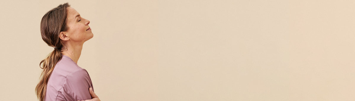 Roosanvärinen työpaita hoitajan yllä, beigellä taustalla